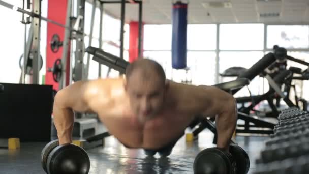 Bodybuilder doen dumbbell push ups — Stockvideo