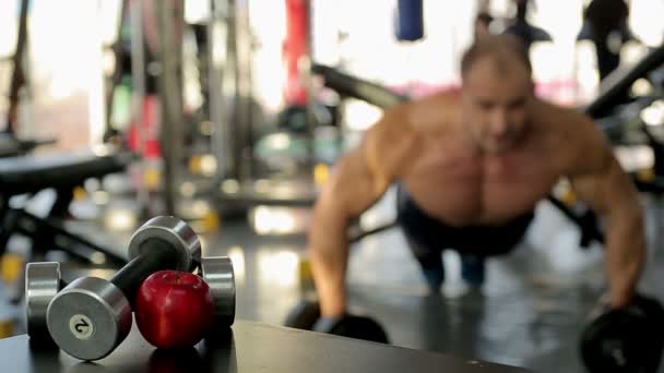 Halterofilista fazendo dumbbell empurrar ups — Vídeo de Stock