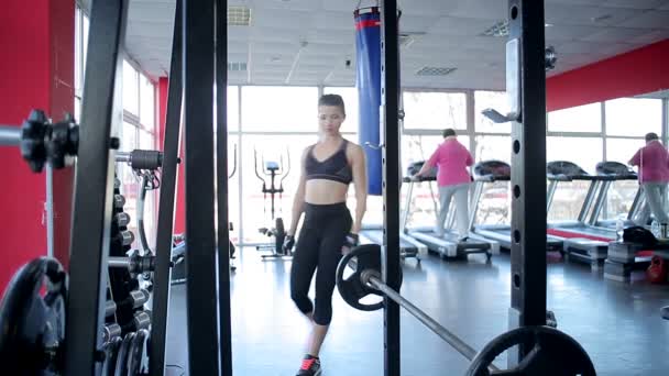 Fitte Athletin beim Training mit Langhantel, übergewichtige Dame beim Laufen auf dem Laufband — Stockvideo