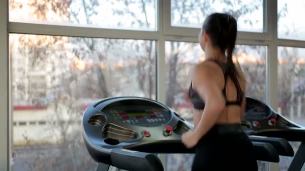 Framgångsrik ung dam träning på löpband i gym, arbetar hårt för att uppnå mål — Stockvideo