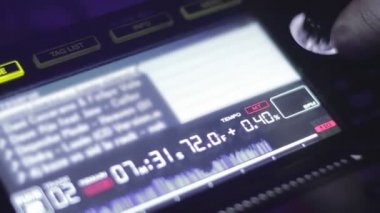 Erkek dj el dönüm düğmeleri karıştırma konsol, ekranda şarkıları çalma listesi