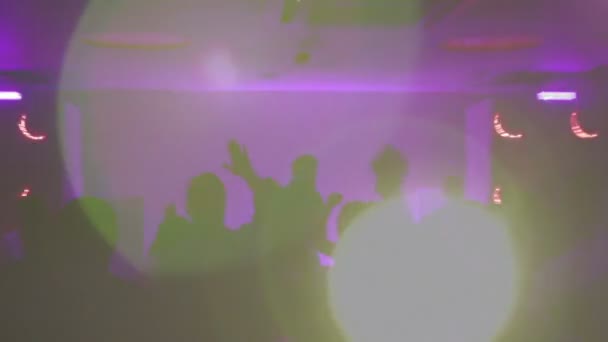 Silhuetas de clubbers festejando na pista de dança, DJ tocando pista no clube noturno — Vídeo de Stock