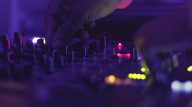 Dj elleri karıştırma konsolundaki düğmelere basıyor. Gece kulübü atmosferi. Parti