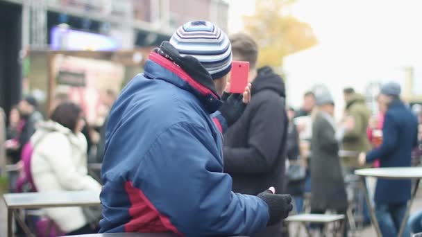 Trabajador migrante tomando selfie, hojeando fotos en smartphone en lugar público — Vídeos de Stock