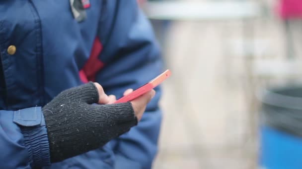 Male hand in old fingerless gloves using touch phone, poor man texting message — Stock Video