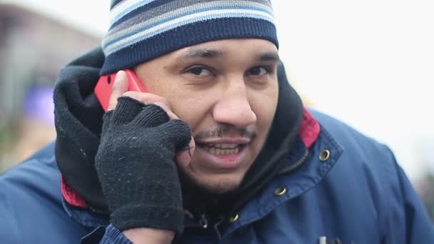 Happy male immigrant wearing shabby work clothes having phone conversation — Stock Video