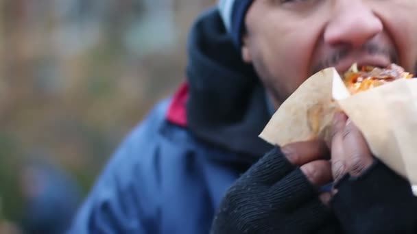 Hombre adicto a la comida chatarra morder y masticar perro caliente grasiento, hábito de comer poco saludable — Vídeo de stock