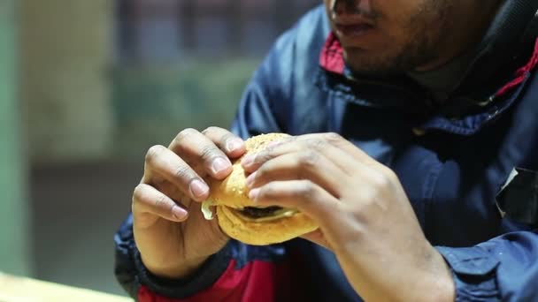 Hombre comiendo hamburguesa en restaurante de comida rápida, dieta poco saludable peligrosa para la salud — Vídeos de Stock