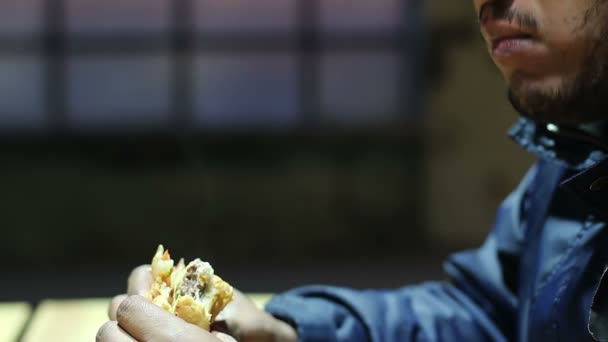 Jovem preguiçoso mastigando sanduíche gorduroso, viciado em junk food ganhando excesso de peso — Vídeo de Stock