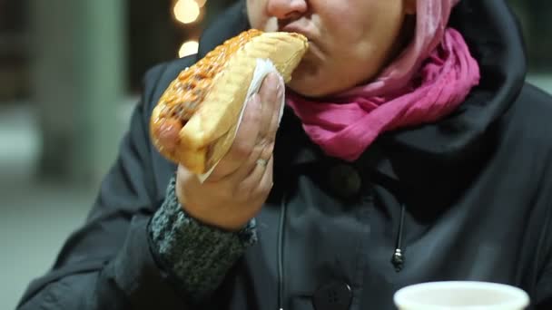 Žena, jíst mastné hot dog na ulici snack baru, přejídání problém s nadváhou — Stock video