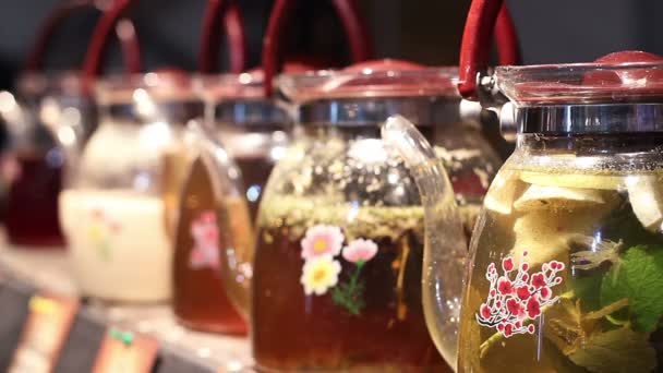 Ampla escolha de bebidas de chá de ervas em bules de vidro em pé no balcão do café — Vídeo de Stock
