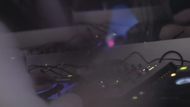 Vista borrosa del DJ trabajando detrás de la consola, tocando música moderna en el club nocturno — Vídeos de Stock