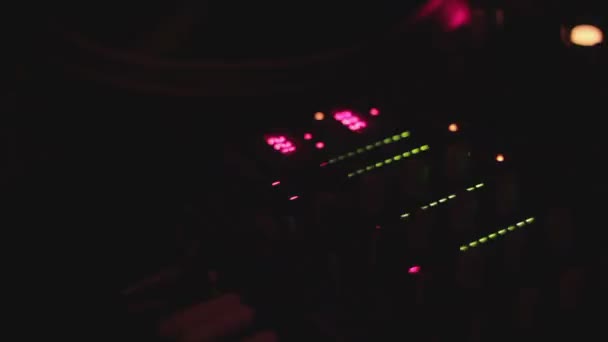 DJ profesional interpretando música en la cubierta de sonido, luces desenfocadas del equipo — Vídeos de Stock