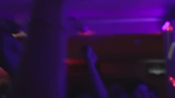 Visitante borracho del club nocturno sosteniendo una copa de cóctel, mucha gente en la pista de baile — Vídeos de Stock