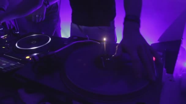 Party in night club, skilled DJ scratching vinyl record, entertaining clubbers — Stock Video