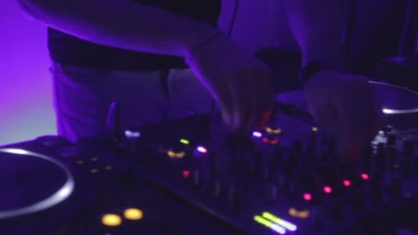 Диджей с помощью оборудования, играющий музыку на вечеринке, атмосфера в ночном клубе — стоковое видео
