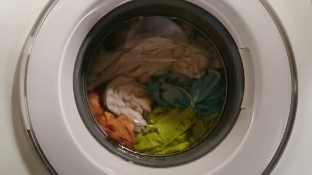 Ropa mojada girando en lavadora, vista a través de vidrio frontal — Vídeo de stock