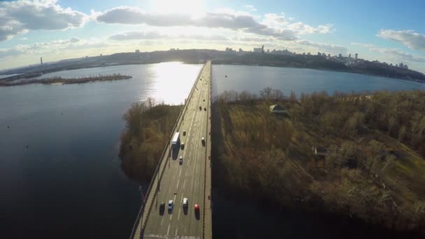 Luchtfoto van panorama van de stad, de zon schijnt fel, brede rivier — Stockvideo