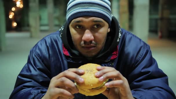 Un uomo premuroso sta per mangiare hamburger. Pasto malsano. Danni alla salute. Fame — Video Stock