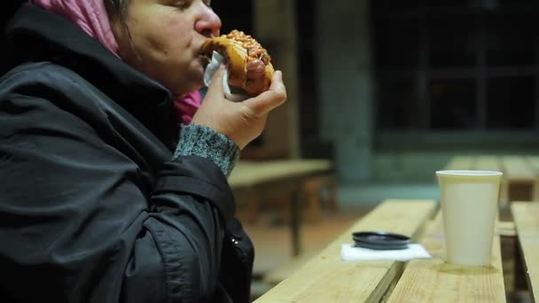 Caridad. Pobre mujer gorda hambrienta comiendo perritos calientes. Alimentos poco saludables, sobrepeso — Vídeos de Stock