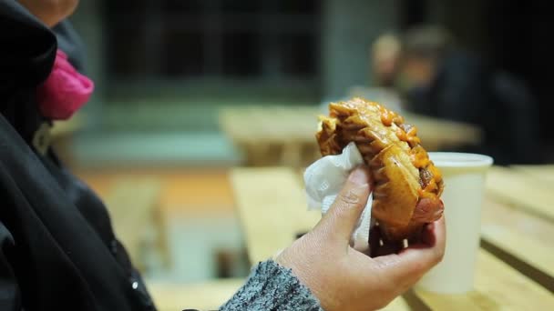 Välgörenhet kampanj. Hungriga och fattiga kvinna äta fet korv och njuter av smaken — Stockvideo