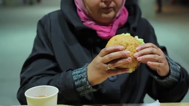 Problemas de saúde, comer demais. Mulher comendo hambúrguer gorduroso no restaurante fast food — Vídeo de Stock