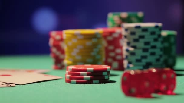 Rack focus shot of pile of poker chips and dice on table, casino background — Stock Video