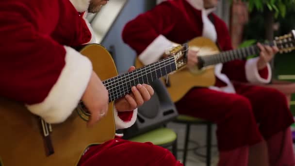 Гитаристы исполняют веселые песни для праздничного настроения посетителей торгового центра — стоковое видео
