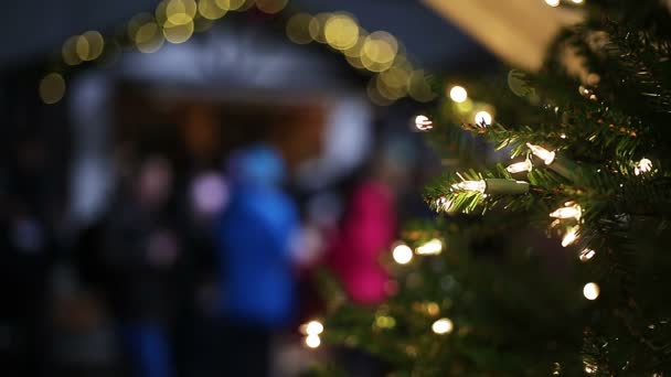 Luces que brillan en el árbol de Año Nuevo decorado en el comercio justo de Navidad, humor festivo — Vídeos de Stock