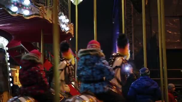 QUIIV, UCRÂNIA - DEZEMBRO 19, 2015. Crianças a montar carrossel. Famílias que passam fim de semana no parque de diversões, crianças e pais se divertindo — Vídeo de Stock