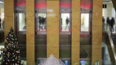 Kalabalık ticaret merkezinde yürüyen insanların siluetleri, Noel satış sezonu