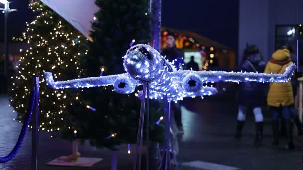 Dekoratives Flugzeug aus funkelnden Lichtern am Flughafen, Weihnachtsrundflüge — Stockvideo