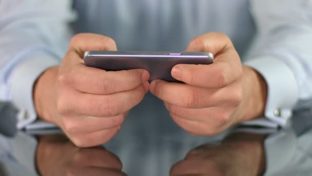 Мужские руки играют в игру на смартфоне, пальцы касаются экрана — стоковое видео