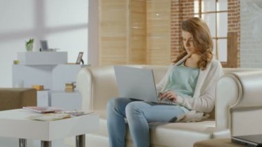 Modern daire içinde laptop üzerinde çalışan güzel bir genç kadın