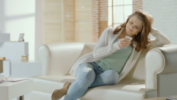 Mooi meisje te typen bericht, chatten op smartphone thuis — Stockvideo