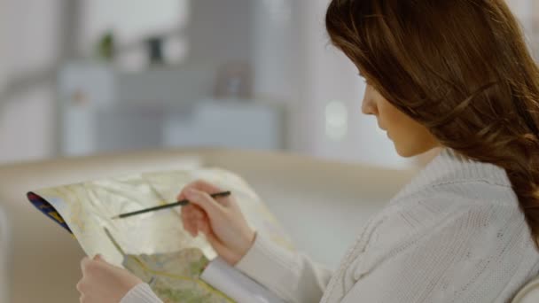 Молодая женщина ищет место на карте, планируя обзорный тур — стоковое видео