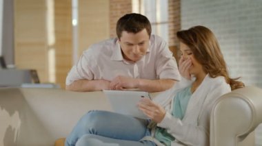 Genç çocuklar gülüyor, evde tablet Pc ile eğleniyor