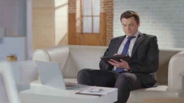 Yakışıklı erkek takım elbise kameraya gülümseyen tablet, çalışma