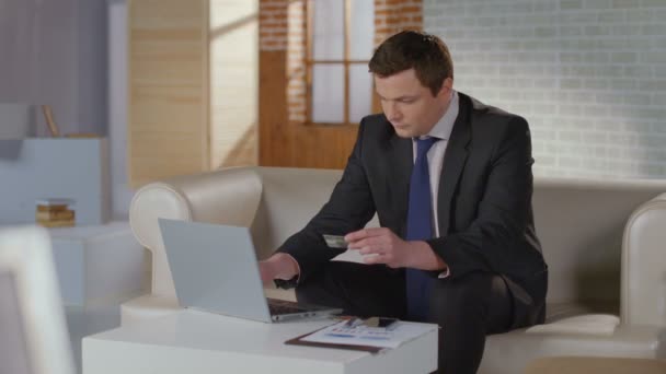 Богач в деловом костюме вставляет номер кредитной карты на ноутбук — стоковое видео