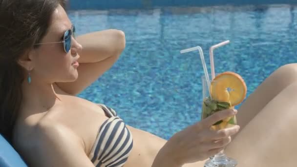 Сексуальная женщина наслаждается коктейлем на солнечном пляже, флиртует, дразнит — стоковое видео