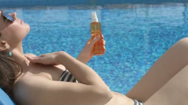 Mutlu genç kadın bronzlaşma, cildi korumak için güneş koruyucu uygulamak — Stok video