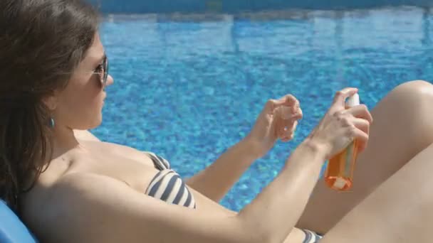 Mujer bastante adulta relajándose en la playa, poniendo protector solar en la piel — Vídeo de stock