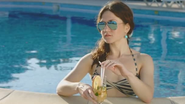 Ung kvinna njuter av long drink i poolen, avkoppling — Stockvideo