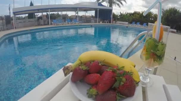 Frutas y bebidas en la mesa junto a la piscina. Fiesta en el resort, hotel — Vídeos de Stock