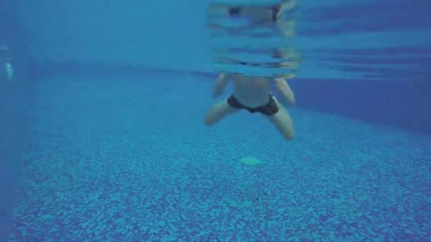 Jovem homem animado nadando na piscina, relaxante, se divertindo — Vídeo de Stock