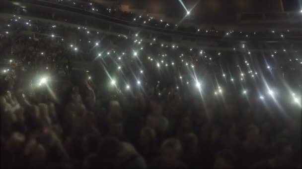Stadio pieno di persone che salutano mani, schermi del telefono brillano nel buio, canzone d'amore — Video Stock