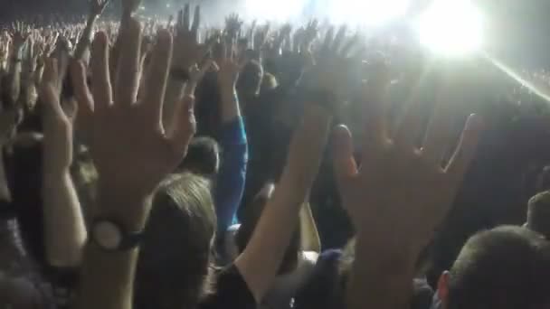 Des milliers de jeunes agitant la main au concert. Les fans apprécient le spectacle d'idoles rock — Video