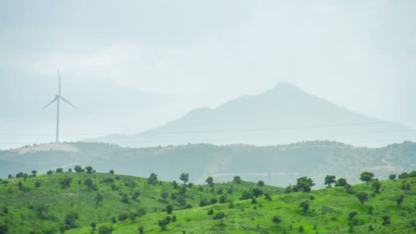 Eco-friendly energy generation sources. Wind turbine against mountain silhouette — Stock Video