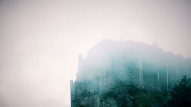 Taş duvarlı siste gizlenmiş korkunç Ortaçağ bina. Mistik bir atmosfer