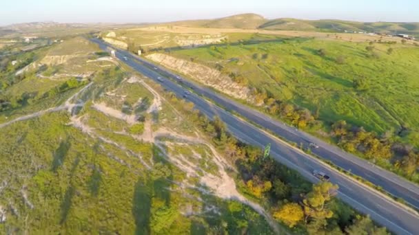 Fantastic aerial shot of beautiful landscape, green hills, busy traffic on road — Stock Video